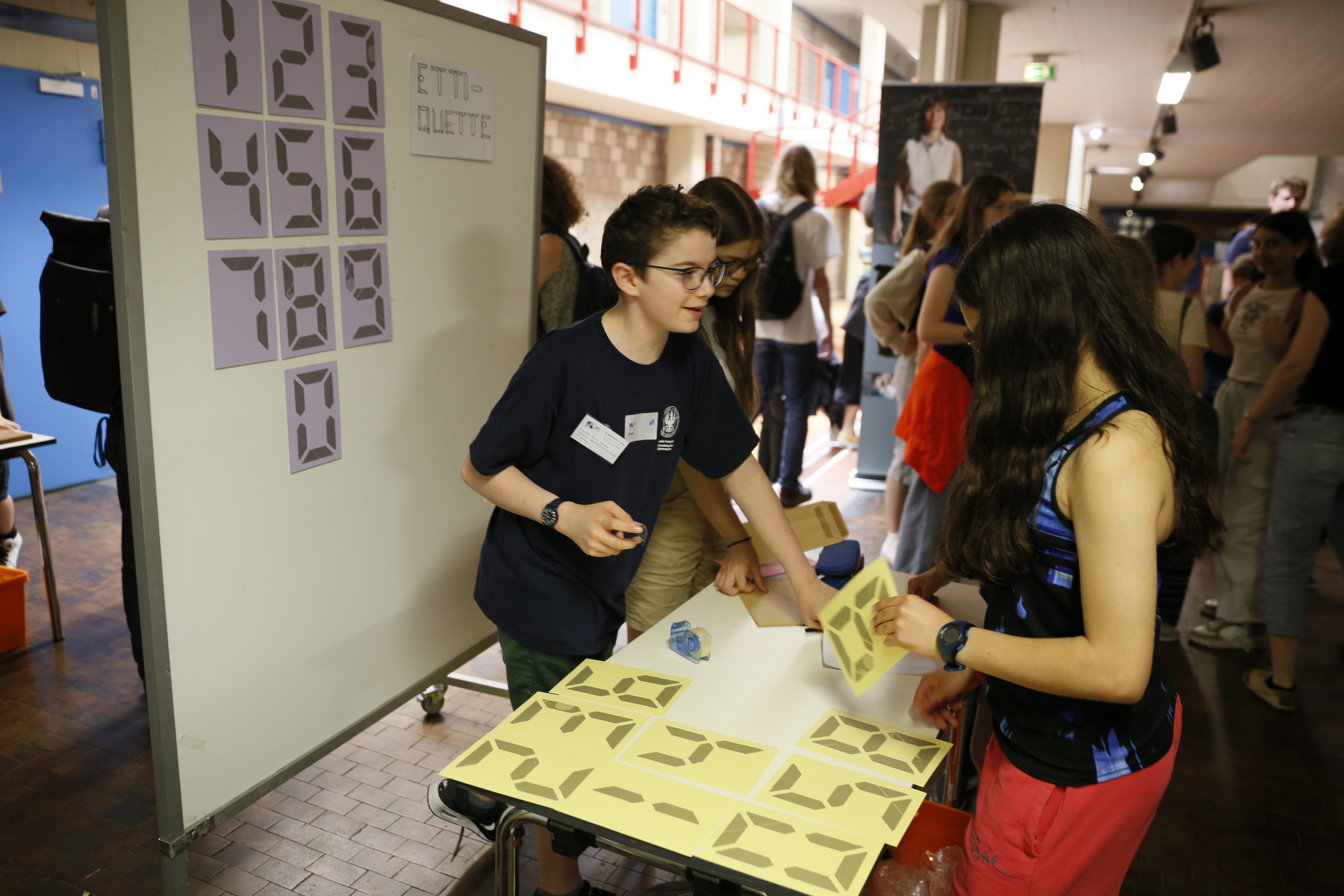 Schüler:innen präsentieren ihre Forschung an einem Stand.